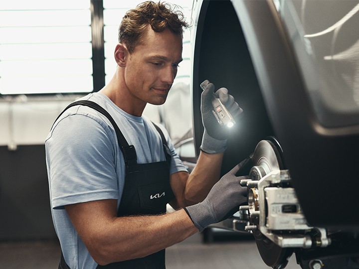 Technicien intervenant sous un véhicule pour réparer un moteur 