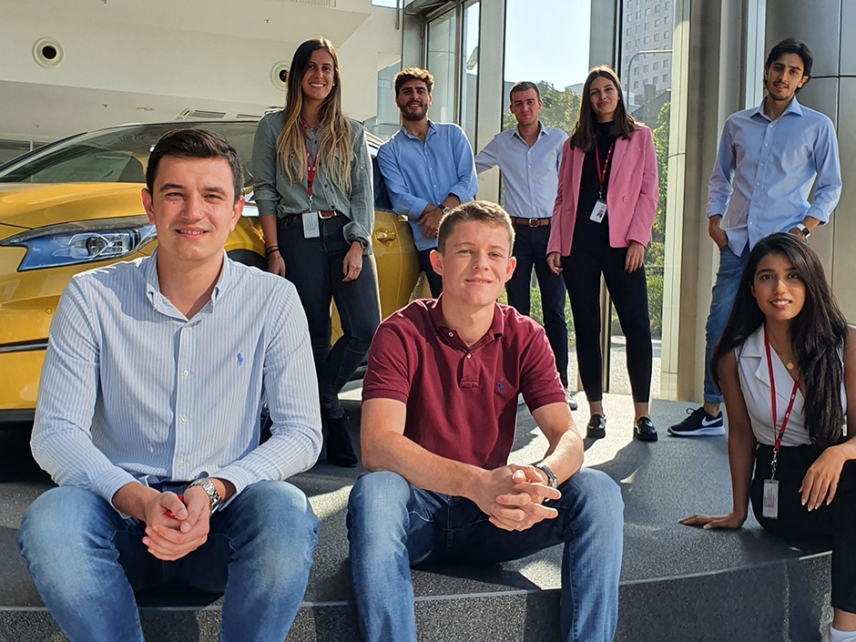 Group of our interns in front of a car