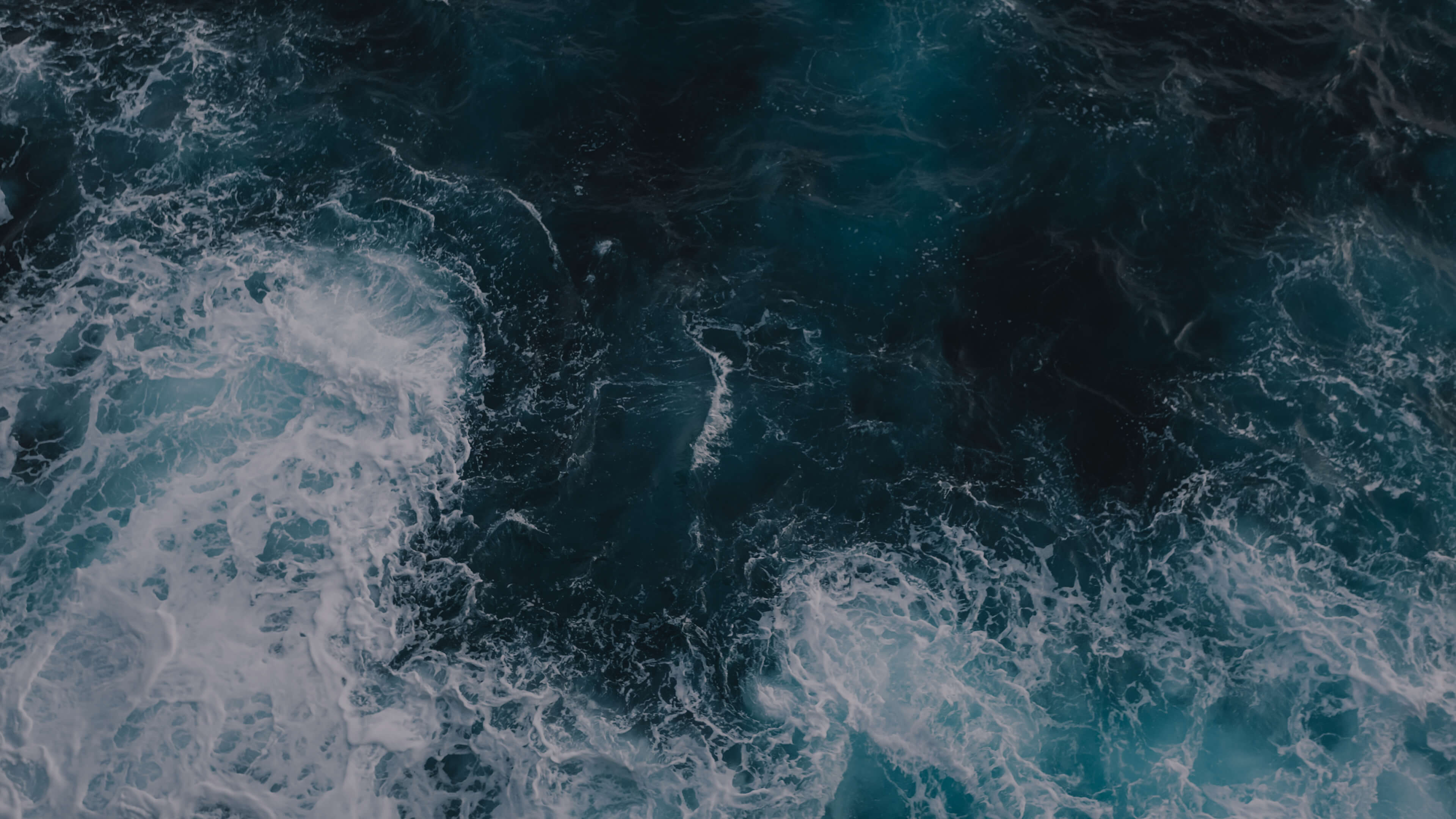 Dramatic aerial view of ocean waves symbolizing Kia’s commitment to sustainable mobility transformation