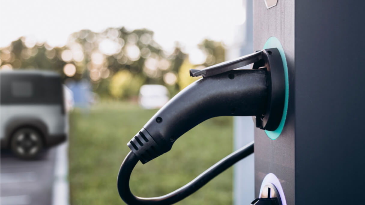 Technician scanning a vehicle with a handheld device to track service status through Kia PBV FMS