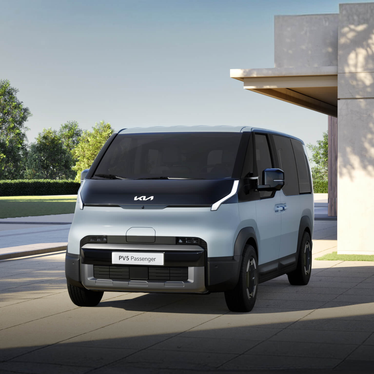 Front-side view of the Kia PV5 Passenger parked in a modern residential setting, highlighting its clean and geometric exterior design