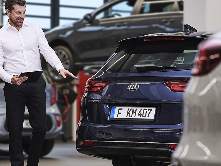 Le mécanicien montre au client la pièce endommagée de la voiture   