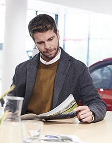 Cliente qui découvre un assortiment d'offres de services clés chez le concessionnaire ou dans une brochure