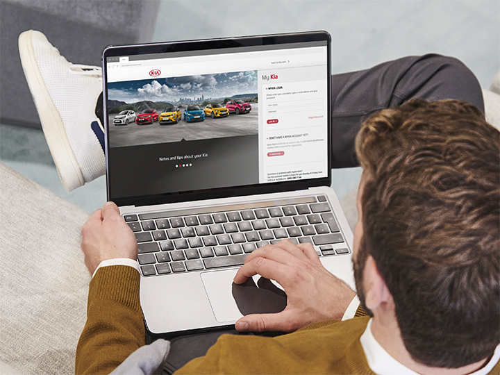 Woman is sitting on the couch and watching Kia video guides