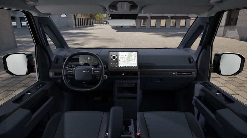 Front interior view of the Kia PV5 Cargo cabin with digital cockpit and wide windshield visibility