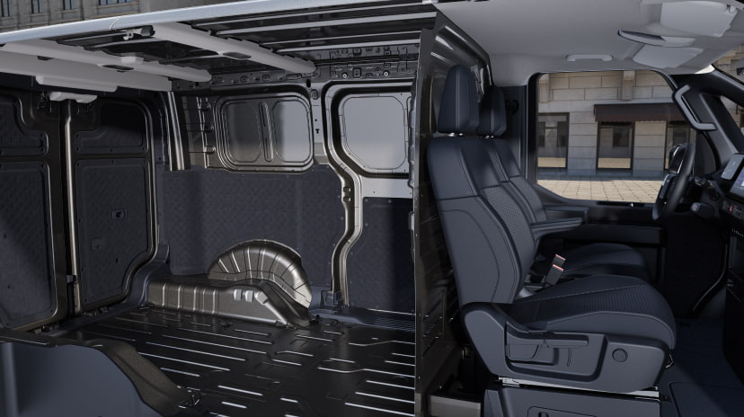 Side interior view of the Kia PV5 Cargo showcasing open cargo space and the front passenger seats