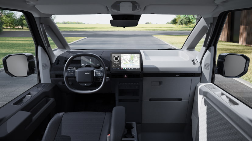 Front interior view of the Kia PV5 Passenger showing panoramic windshield and dashboard layout